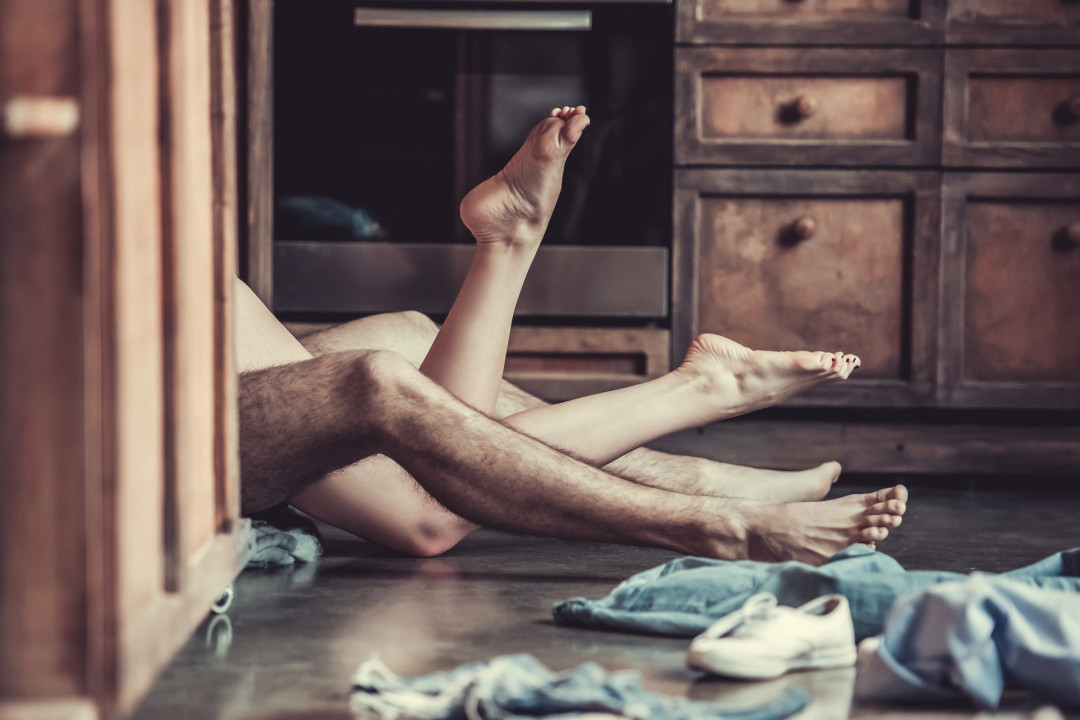 Man and woman's feet hanging from the bed
